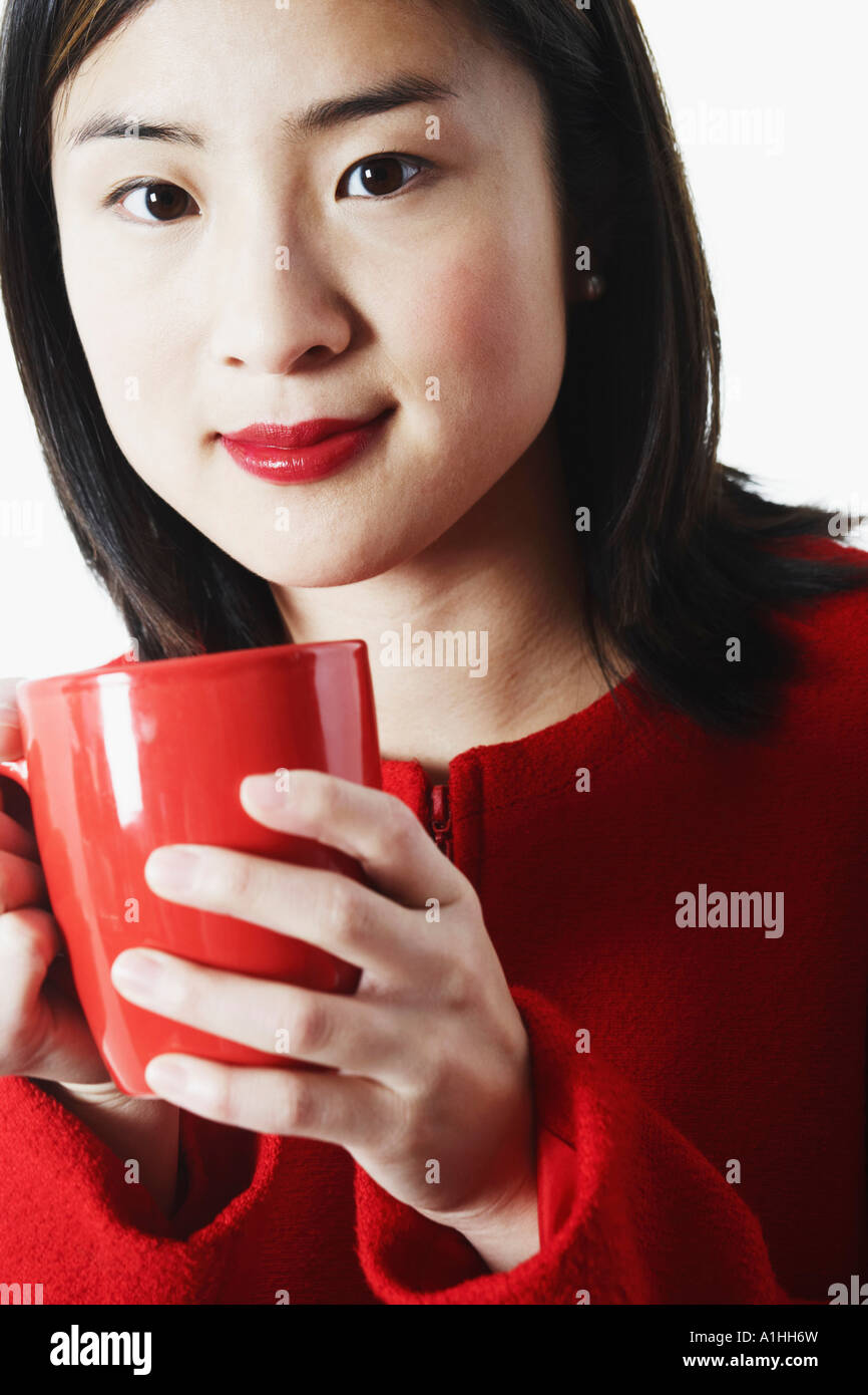 Ritratto di una giovane donna che mantiene una tazza di caffè Foto Stock