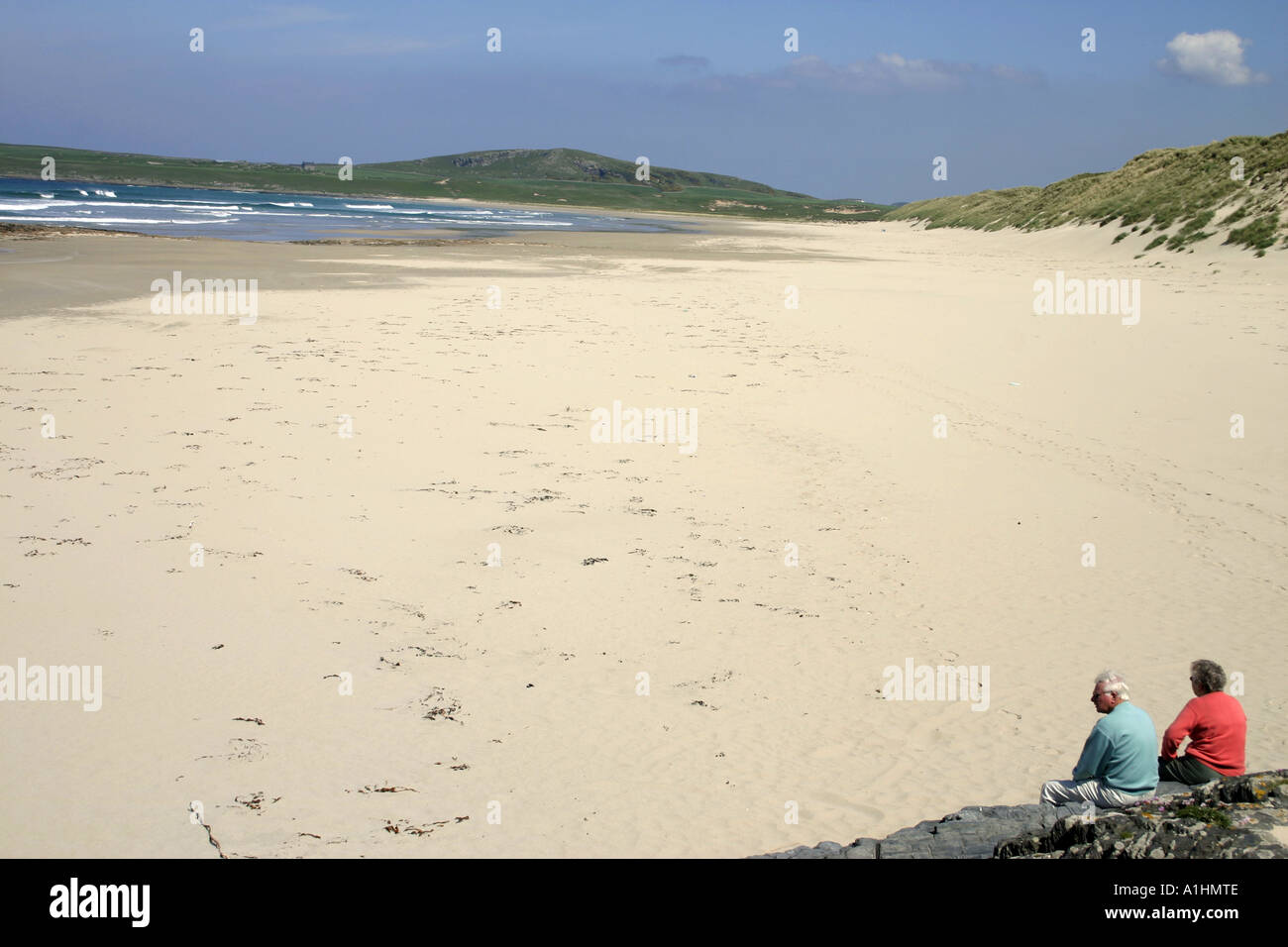 Due persone sedute sulla spiaggia sabbiosa di Ardnave sull'isola scozzese di Islay Ebridi Interne in Scozia UK Foto Stock