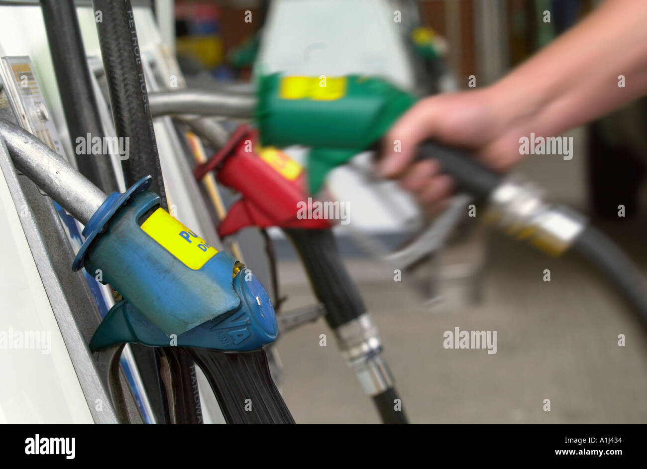 Una mano raggiunge per la pompa senza piombo in corrispondenza di una stazione di benzina, Regno Unito Foto Stock