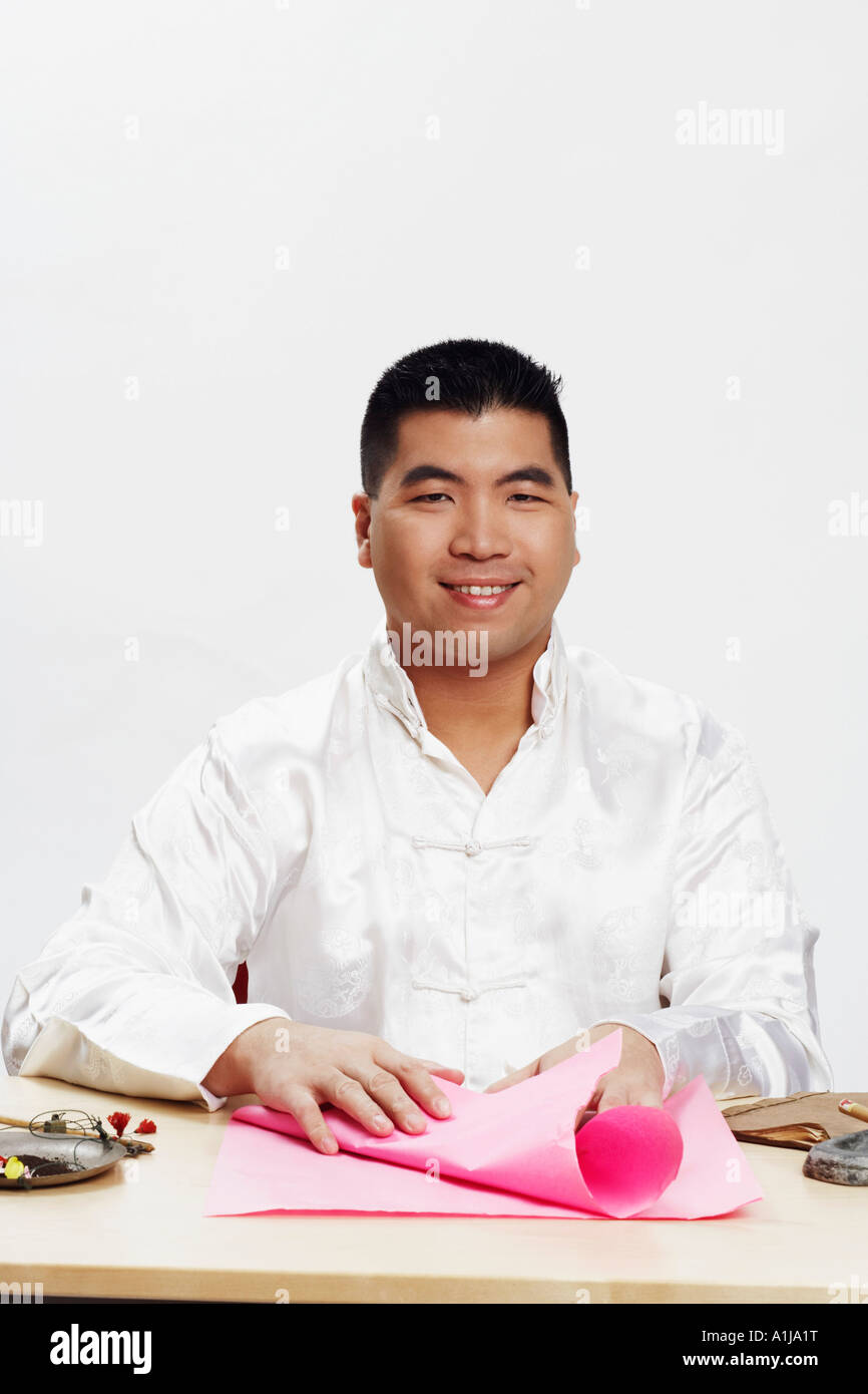 Ritratto di un giovane uomo con carta da imballaggio e sorridente Foto Stock