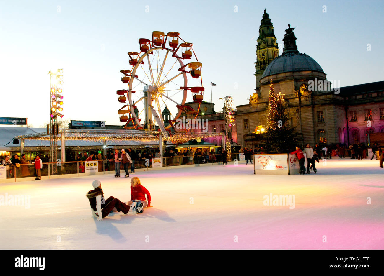 Winter Wonderland evento al di fuori del Municipio di Cardiff Wales UK con persone a pattinare sulla pista di ghiaccio e la ruota panoramica Ferris in background Foto Stock