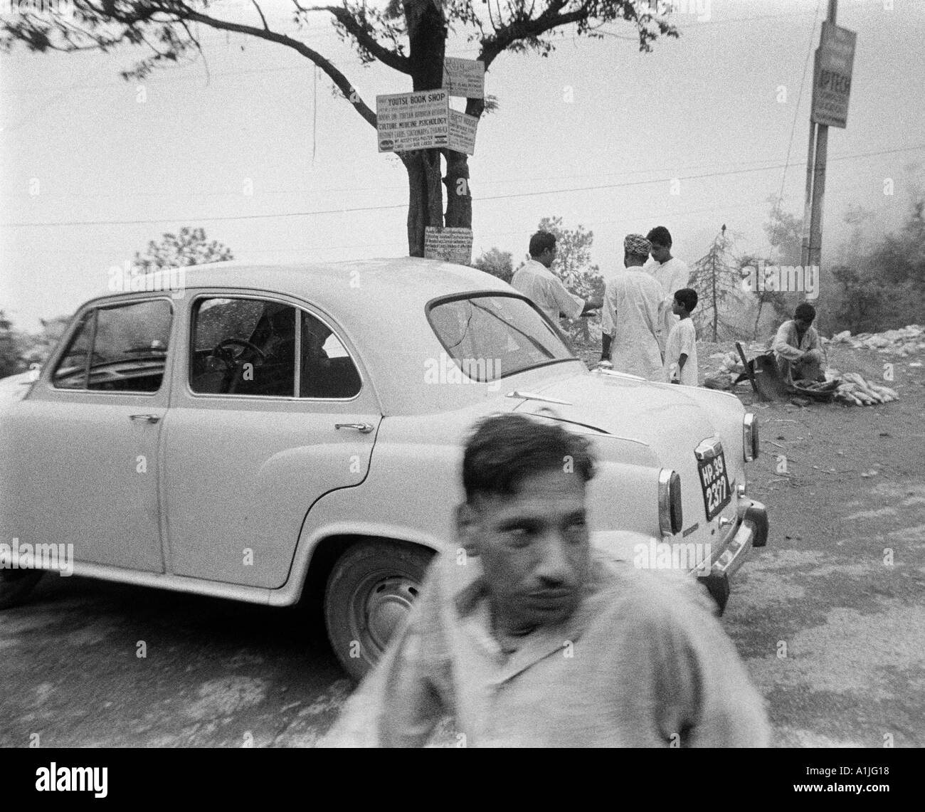 Auto e uomo sulla strada del tempio in McLeod Ganj Kangra Valley Himachal Pradesh India Foto Stock