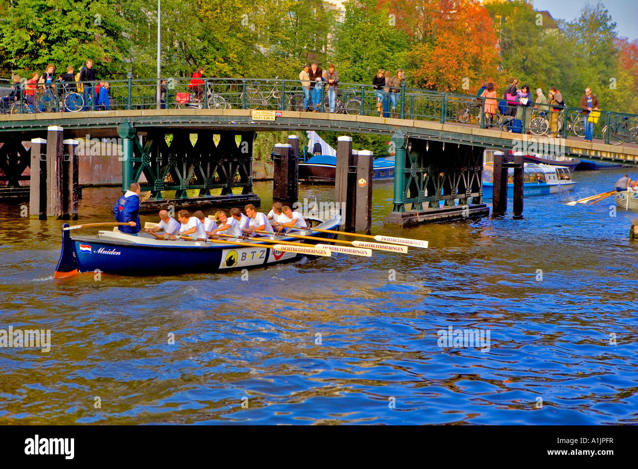 Il canottaggio gara equipaggio negoziando stretto ponte sui canali di Amsterdam Foto Stock