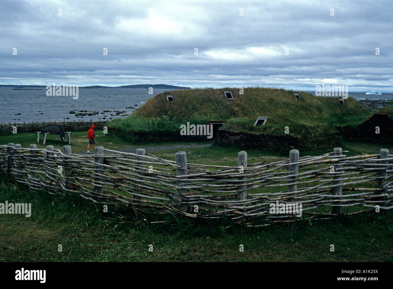 Visitatore ispeziona un Viking sod house presso l'Anse aux Meadows Sito Storico Nazionale di Terranova, del Canada Foto Stock