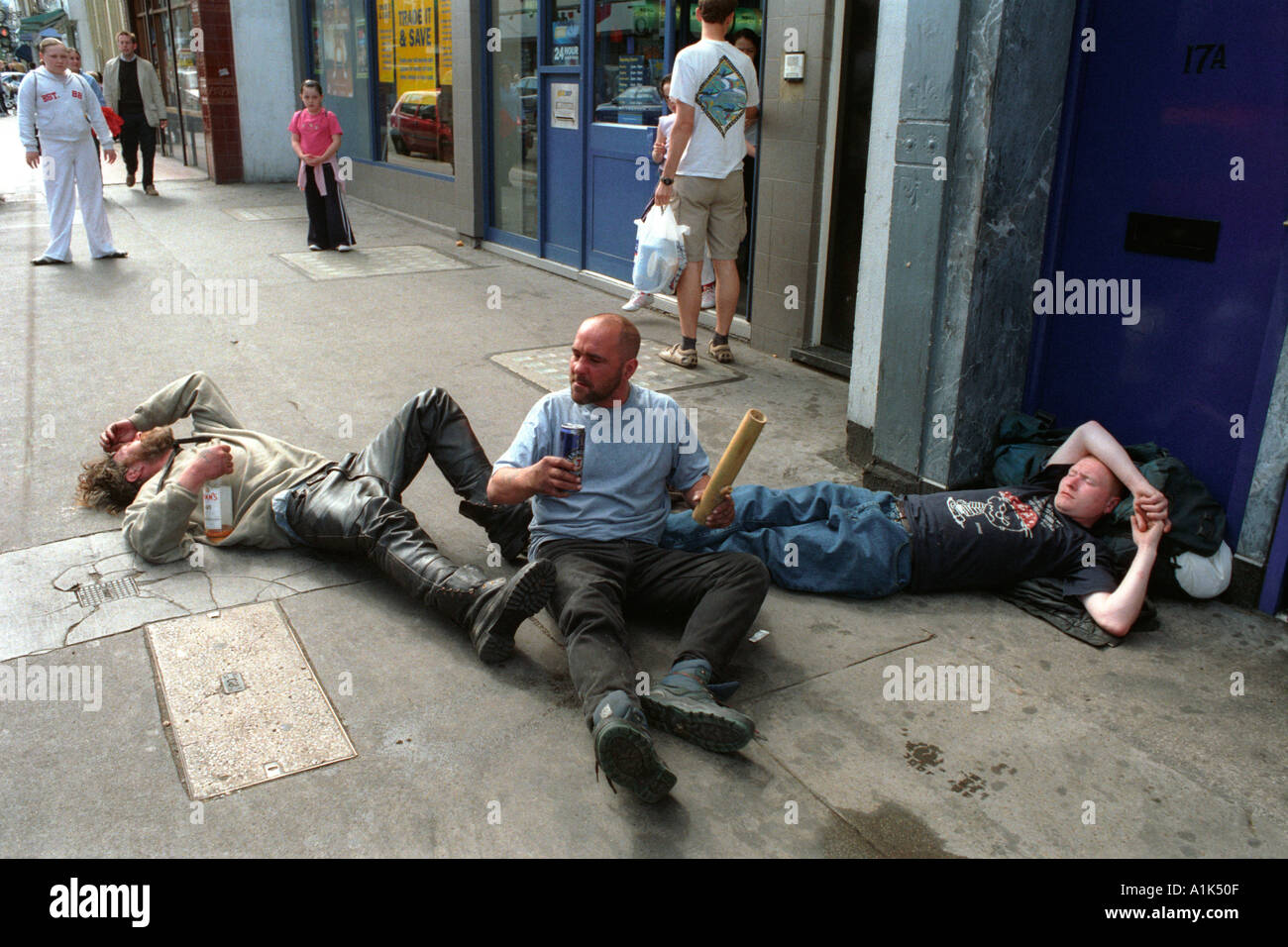 Uomini ubriachi che cadono sopra il rotolamento sul marciapiede ubriaco. Foto Stock