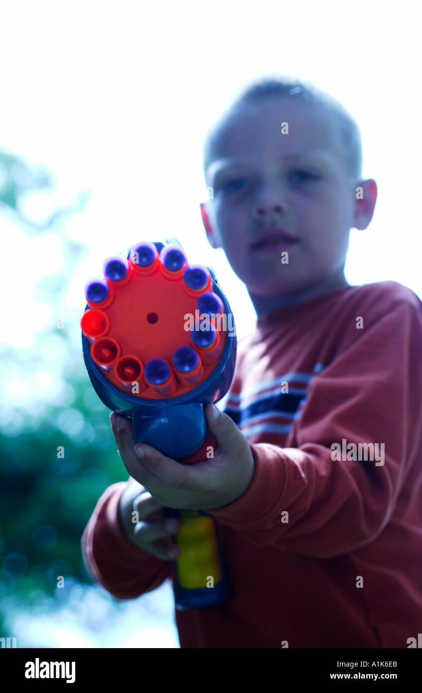 5 anno vecchio ragazzo puntando pistola giocattolo Foto Stock