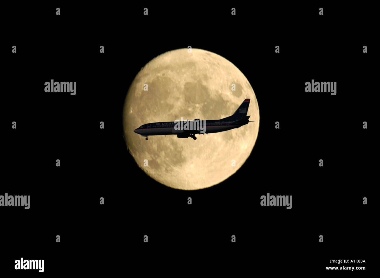Silhouette di un aereo in una impostazione luna la sera come si prepara a terra Foto Stock