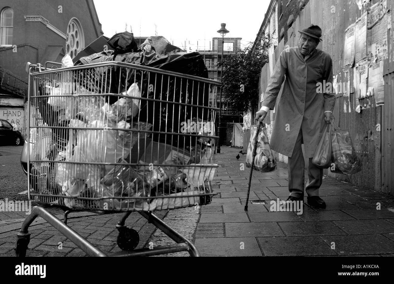 Uomo anziano che trasportano shopping in East End di Londra Foto Stock
