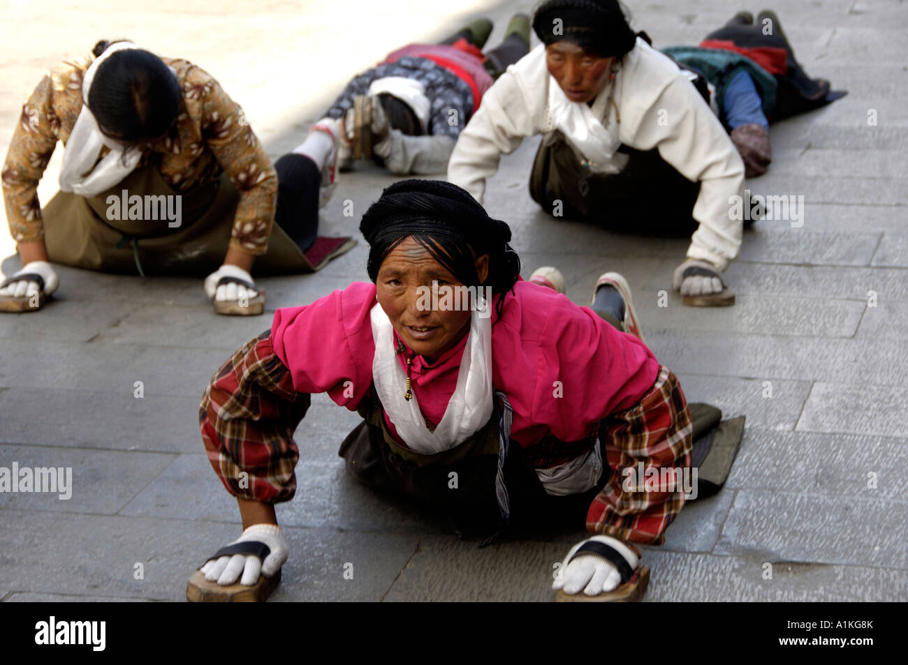 Il Tibetano pellegrini pregano sulla strada per il monastero di Jokhang a Lhasa 18 Ott 2006 Foto Stock