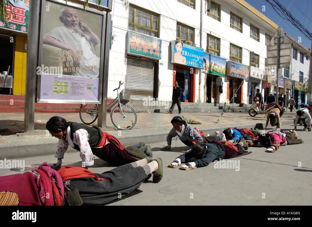 Il Tibetano pellegrini pregano sulla strada per il monastero di Jokhang a Lhasa. 18-ott-2006 Foto Stock