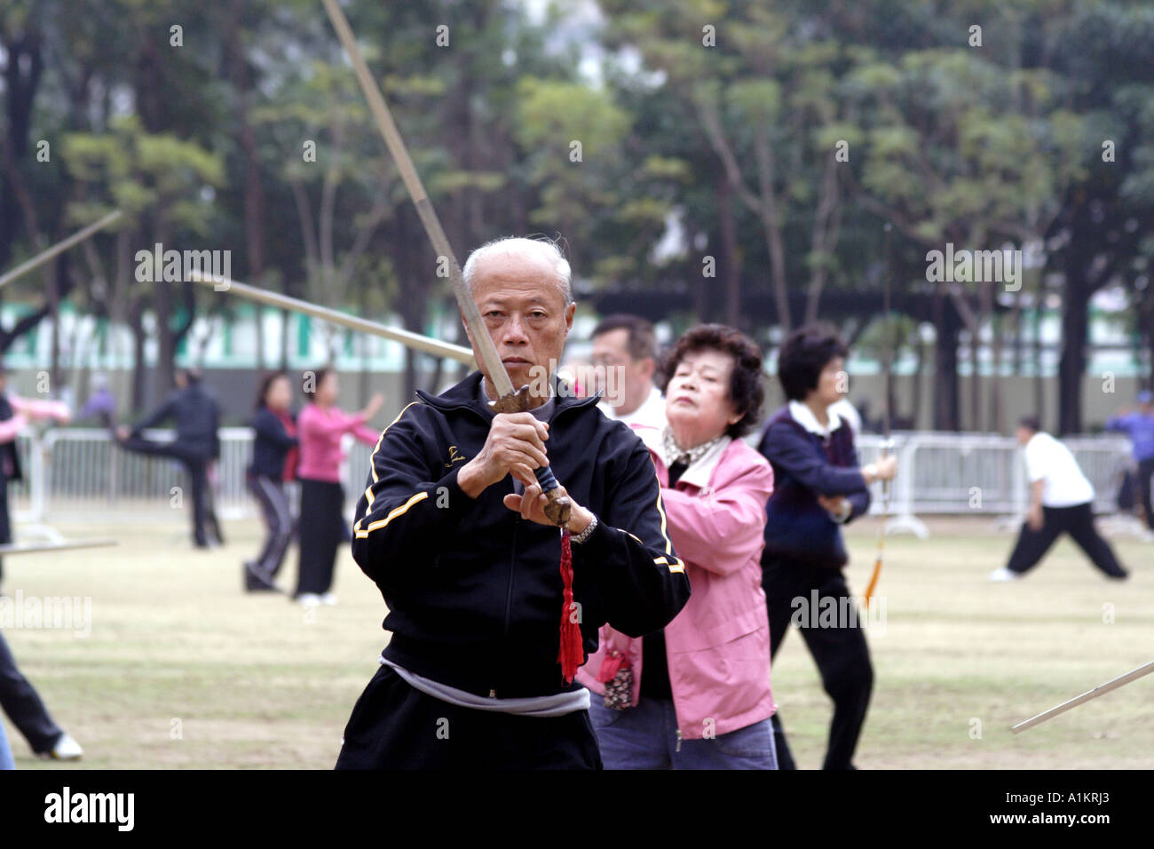 Esercizio di armati. L'uomo praticare il Tai Chi con la spada in Victoria Park, Hong Kong Foto Stock