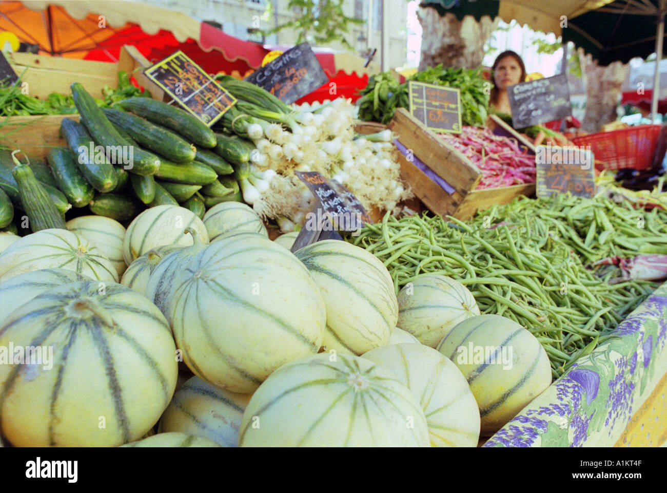 Frutta e verdura in un mercato in stallo al posto di Richelmi square in Aix en Provence Francia meloni squash zucchine cipolle haricots Foto Stock