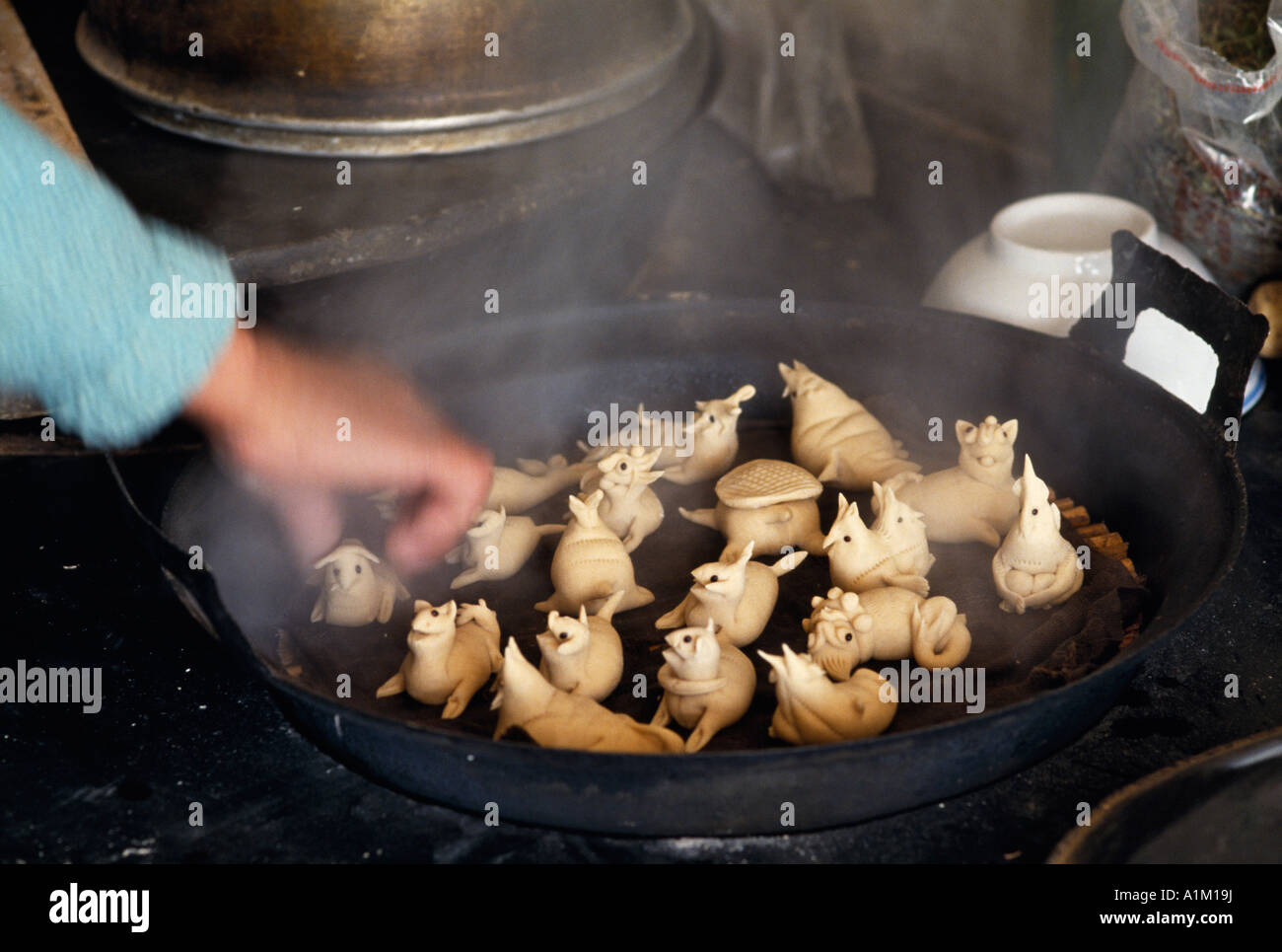 Cina Provincia di Shaanxi Loess Plateau per la cottura a vapore fatta di pasta a forma di animale panini nel wok Foto Stock