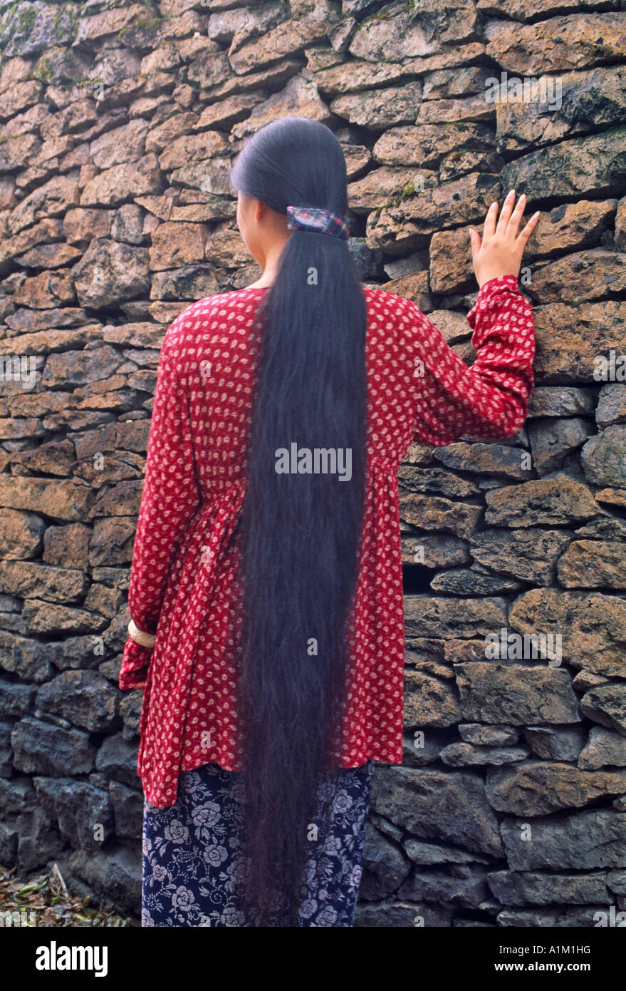 La Cina nella provincia di Zhejiang Shaoxing ragazza con i capelli lunghi dal vecchio muro Foto Stock