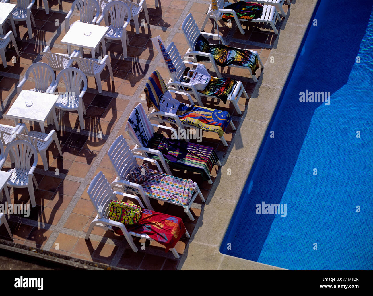 Sedie a sdraio alla piscina hotel prenotato in anticipo Foto Stock