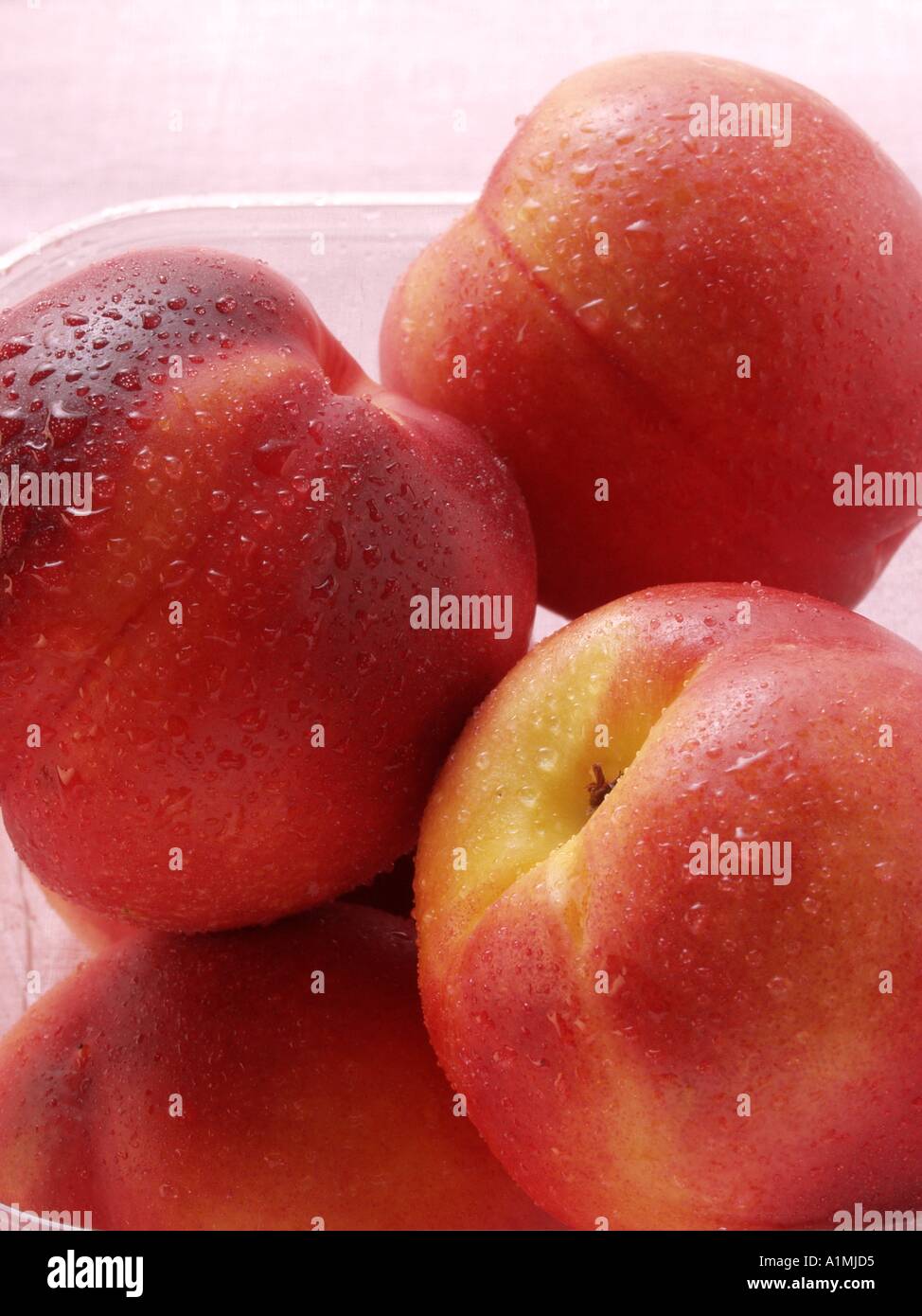 Le pesche noci con gocce di acqua nel contenitore in plastica 2 Foto Stock
