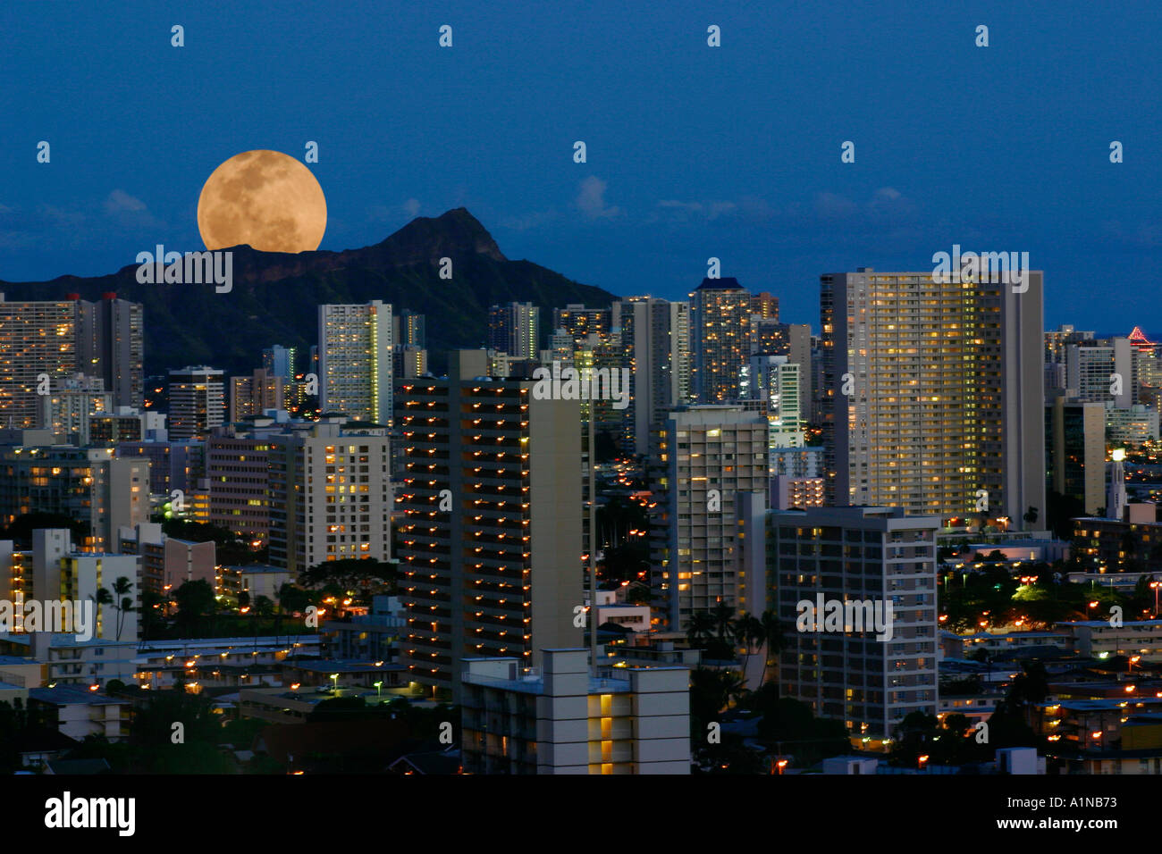 La luna piena si elevano al di sopra della Diamond Head di Waikiki skyline al tramonto Honolulu Oahu Hawaii Foto Stock