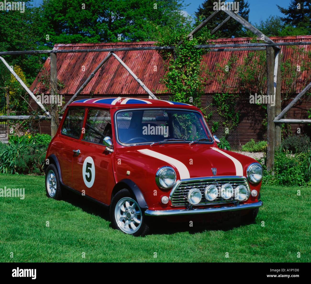 Red Austin Mini in un paese di lingua inglese giardino Foto Stock