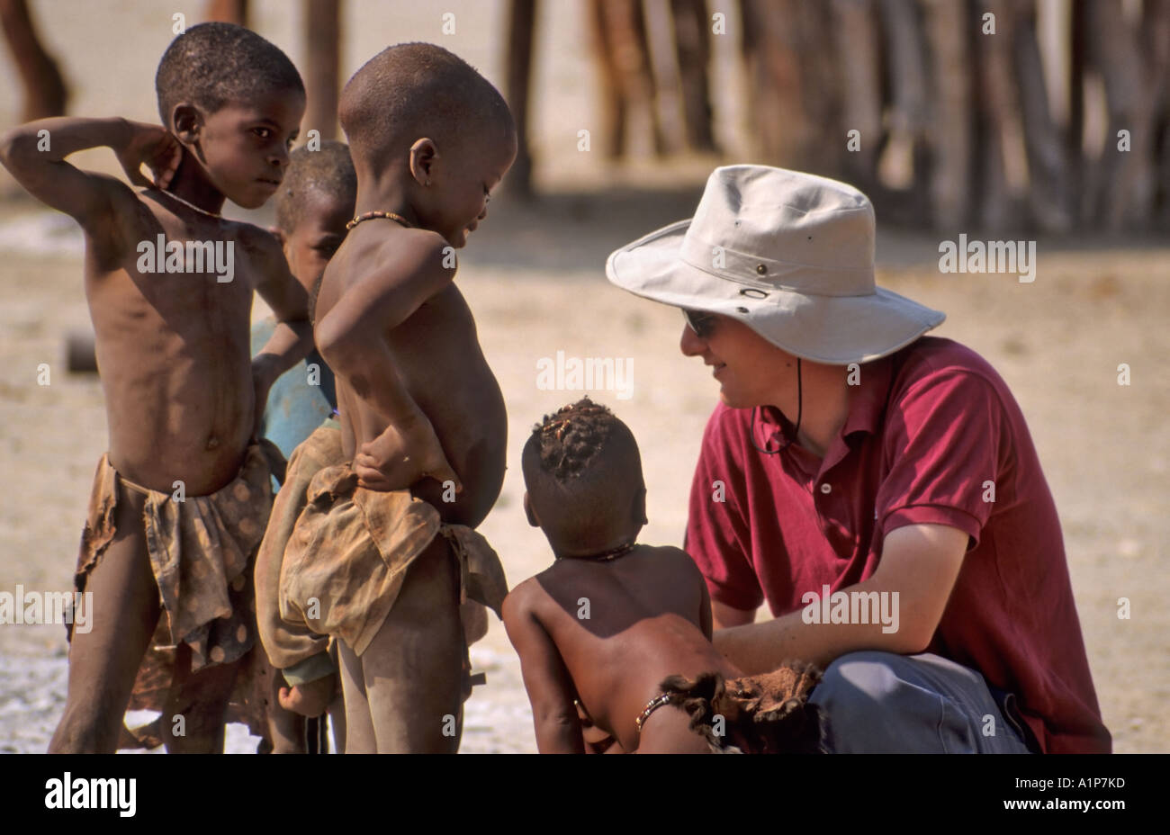 Tourist chiacchierando con i bambini Himba, Namibia Foto Stock