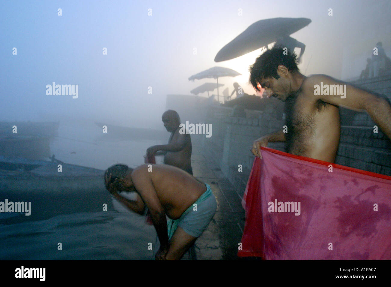 Gli uomini prendere un bagno di religiosi per pulire le loro anime dai peccati passati nel sacro Gange nella città di Varanasi in India del nord Foto Stock