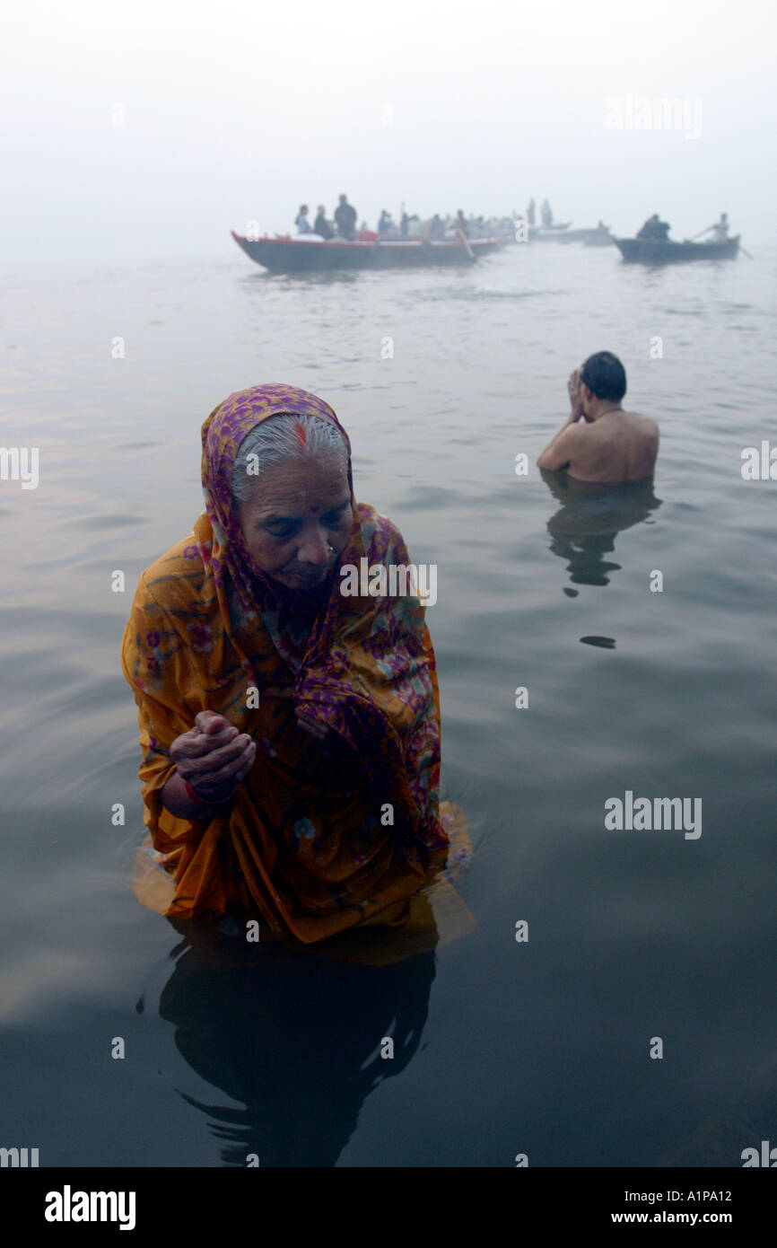 Una donna prende un bagno di religiosi per pulire la sua anima da peccati passati nel sacro Gange a Varanasi (Benares) in India del nord Foto Stock