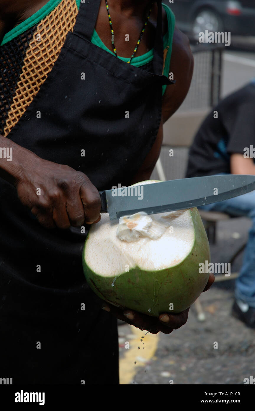 Il taglio di una noce di cocco in preparazione alla vendita in stallo di strada. Foto Stock