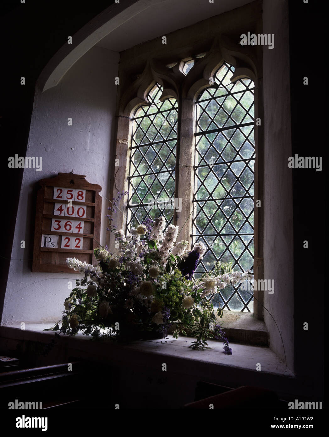 Fiori nella finestra della chiesa del villaggio a Farnborough Foto Stock