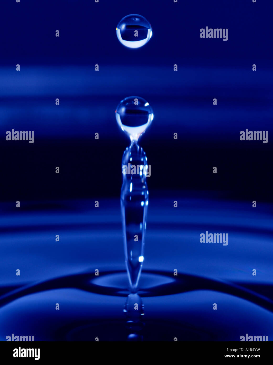 Ancora la vita di blu goccia di acqua al di sopra di una pozzanghera congelata nel tempo Foto Stock
