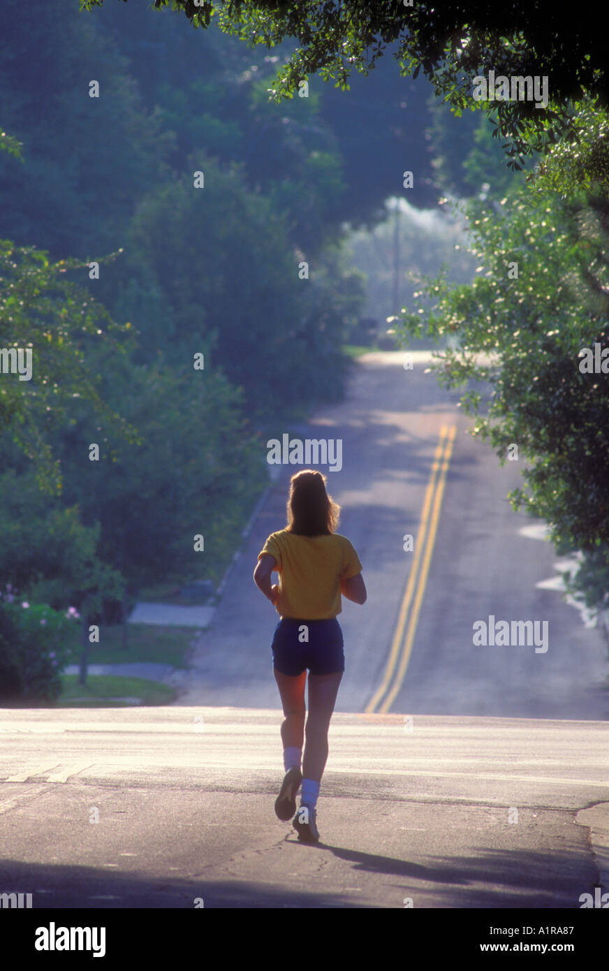 Giovane donna jogging in periferia Foto Stock