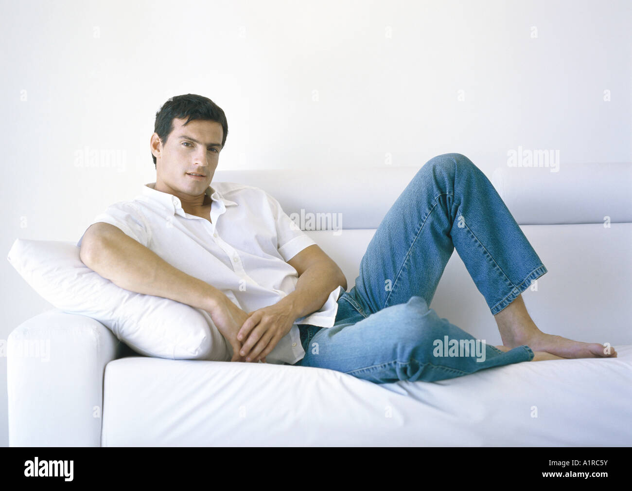 L'uomo sdraiati sul divano Foto stock - Alamy