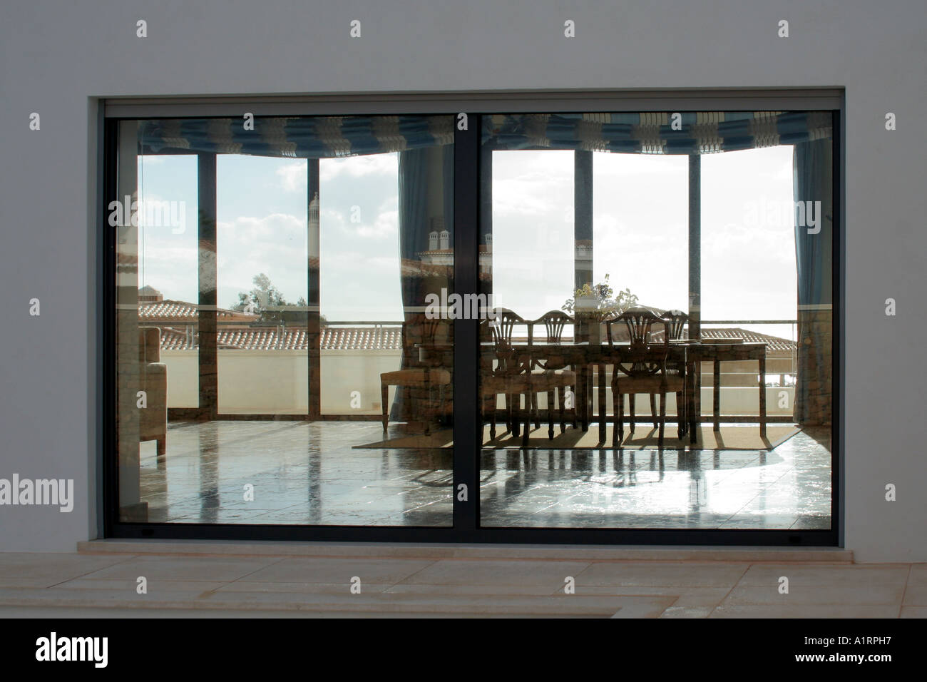 Ambiente Casa Modernista con una vista sala da pranzo visto dall'esterno attraverso la finestra di casa vicini riflettendo Foto Stock