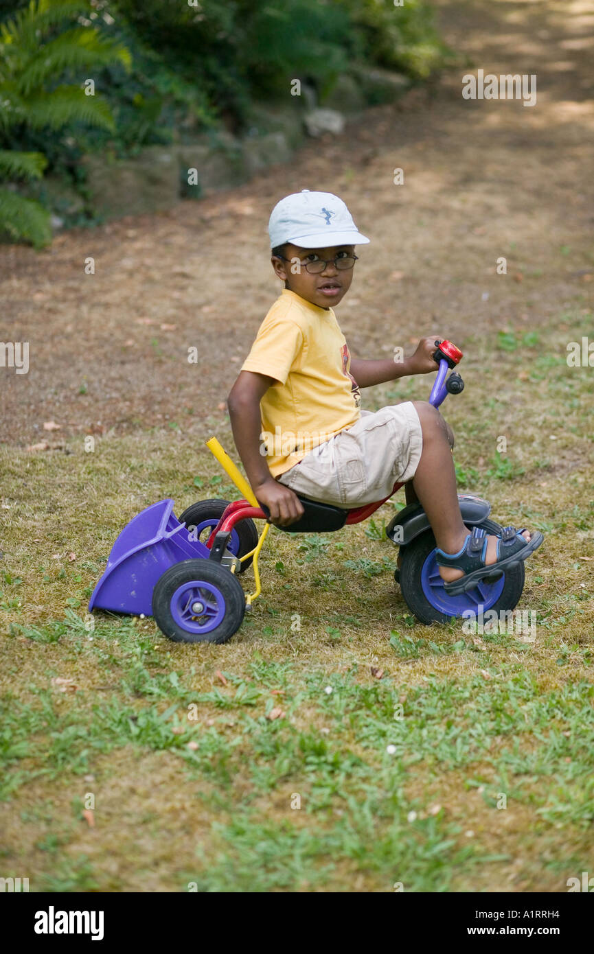 Black Boy giocando con il triciclo Foto Stock