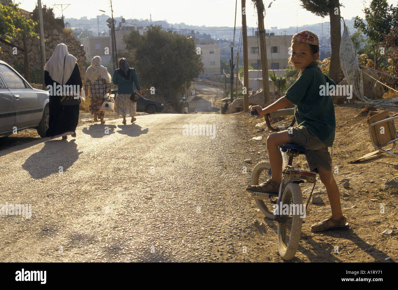 Coloni ebrei in Cisgiordania HEBRON IN ESECUZIONE SU STRADA FINO A TEL RAMIDA DECANTATORE KID sul suo lato donna palestinese sul suo 1996 Foto Stock