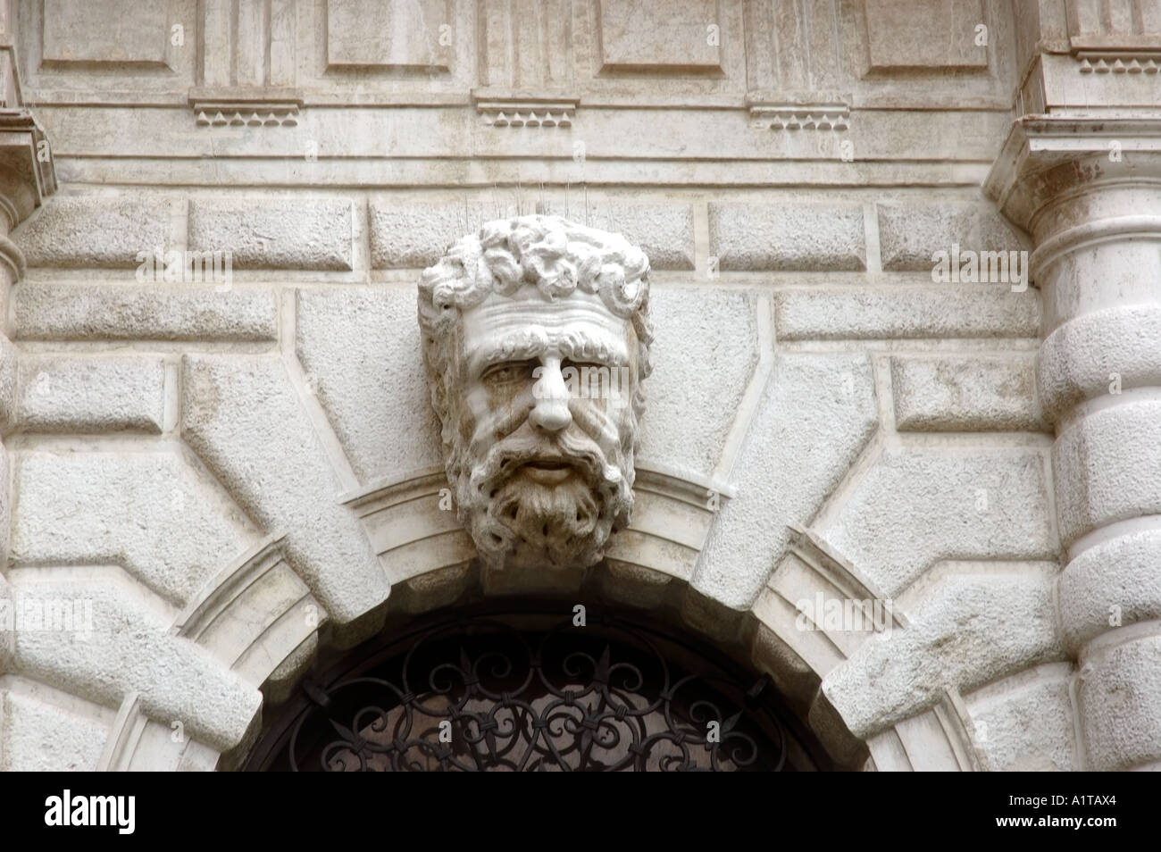 Venezia Italia, dettaglio architettonico, porta di ingresso Scultura a basso rilievo faccia dell'uomo in pietra sulla facciata dell'edificio Foto Stock