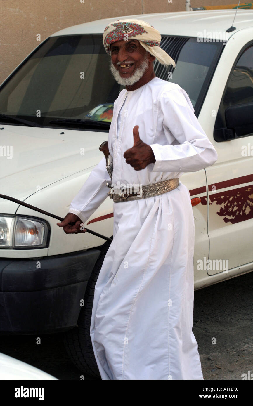 Il vecchio uomo in un suk in Sinaw, vicino a Nizwa, Oman indossando un tradizionale coltello khanjar Foto Stock