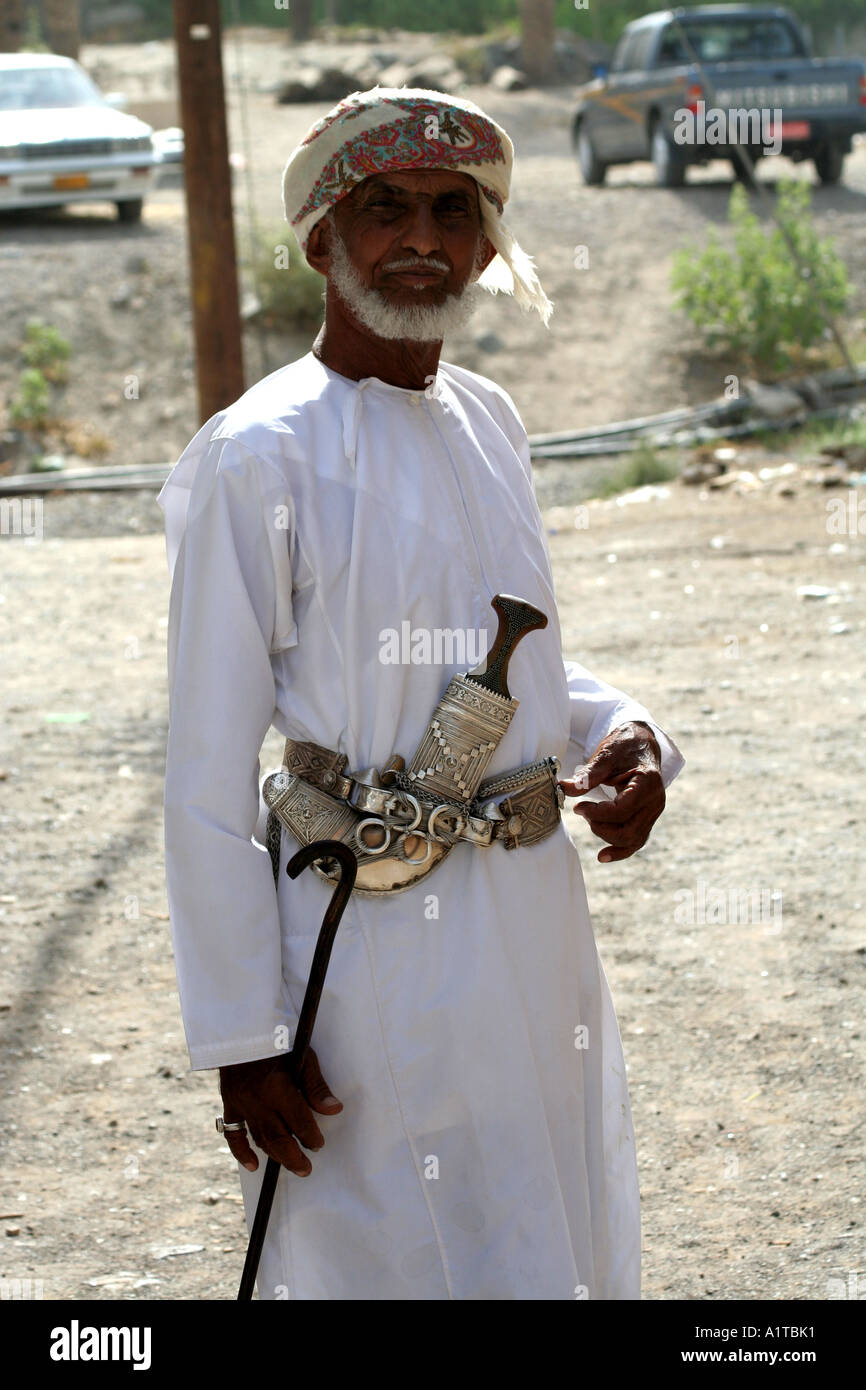 Il vecchio uomo in un suk in Sinaw, vicino a Nizwa, Oman indossando un tradizionale coltello khanjar Foto Stock