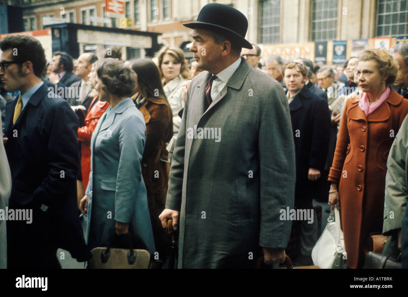 London Transport Train pendolari anni '1970 Regno Unito. Stazione ferroviaria di Waterloo 1972 City Gent in bowler Hat roll ombrelli folle aspettano il treno in ritardo. Foto Stock