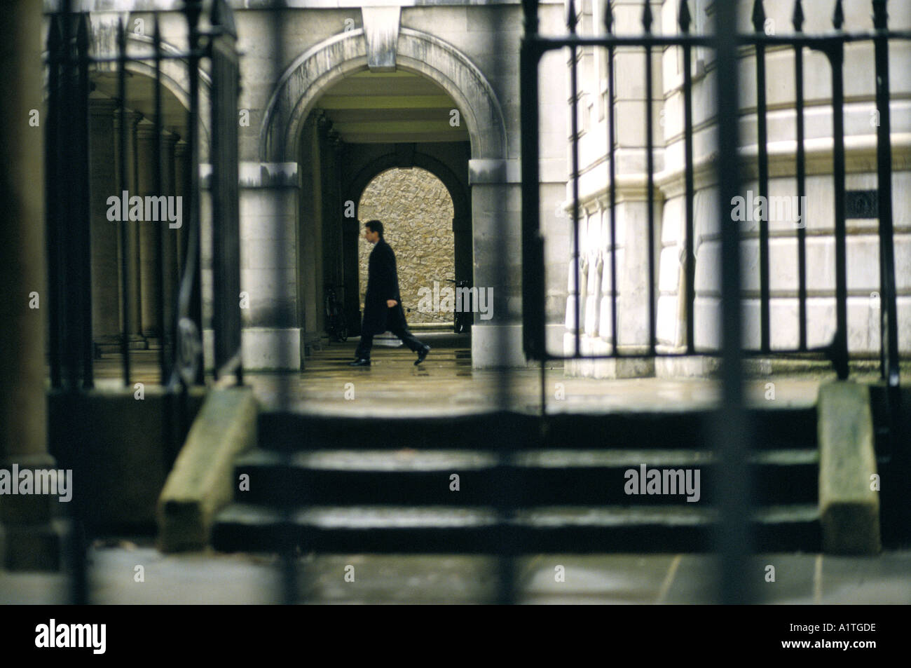 Guardando attraverso la ringhiera uomo cammina nel corridoio sotto arcate MIDDLE TEMPLE LANE CITY OF LONDON Foto Stock