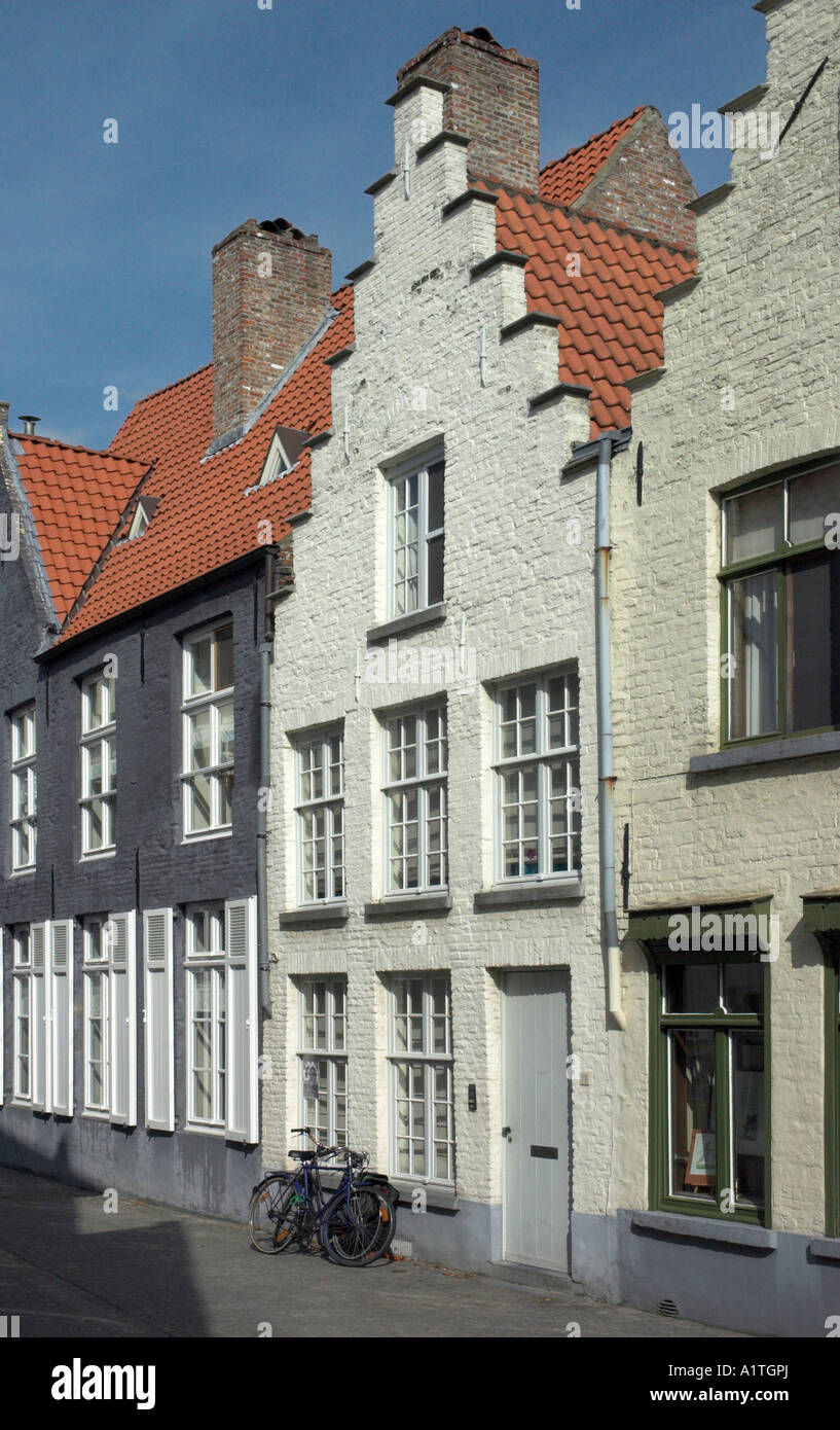 Biciclette appoggiata contro il muro in una strada vuota nella graziosa cittadina medievale di Bruges Foto Stock