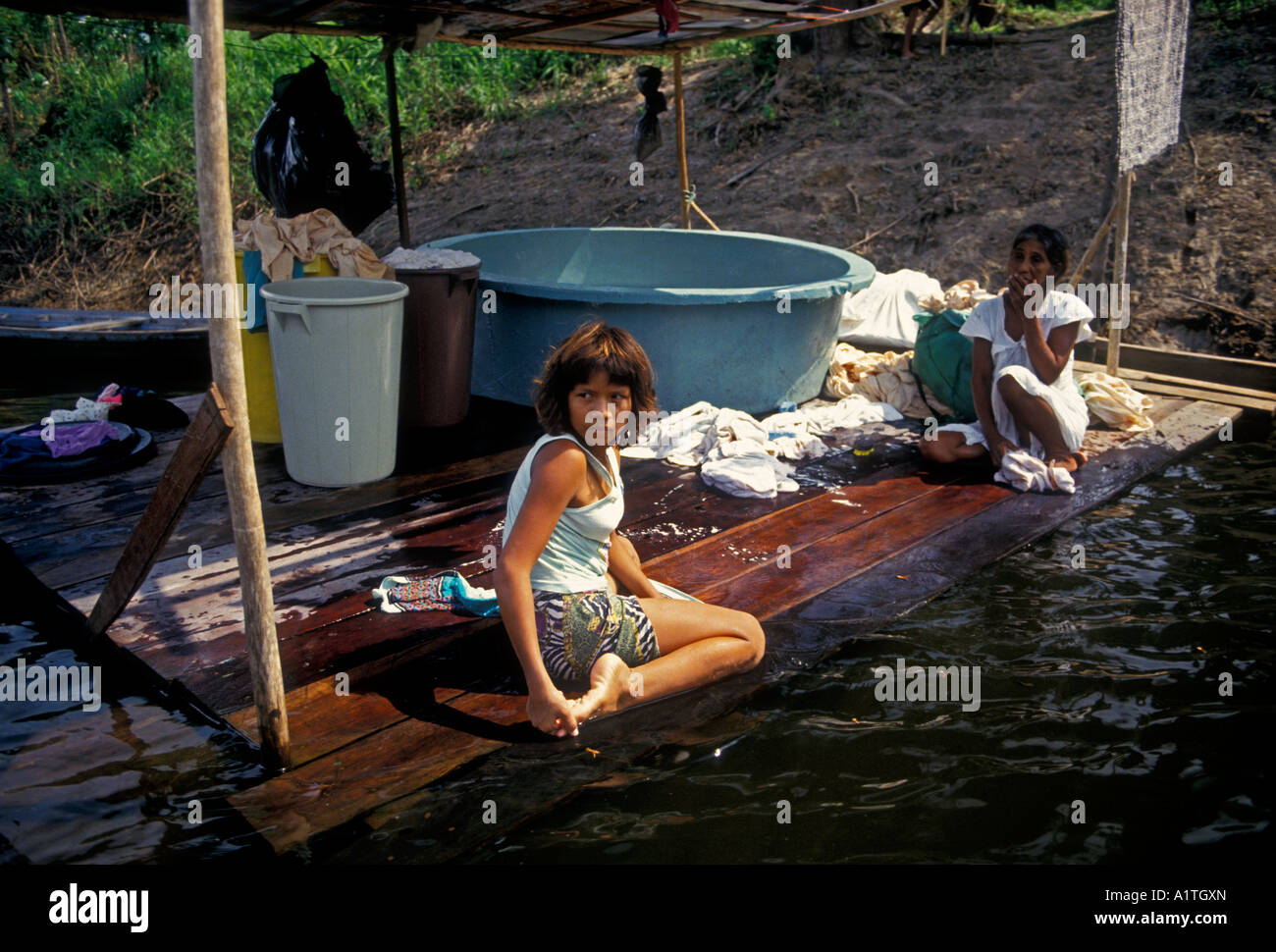 1, una ragazza brasiliana di bambini vestiti di lavaggio panni di pulizia nel fiume Rio Ariau, Ariau River, Amazonas Stato, Brasile, Sud America Foto Stock