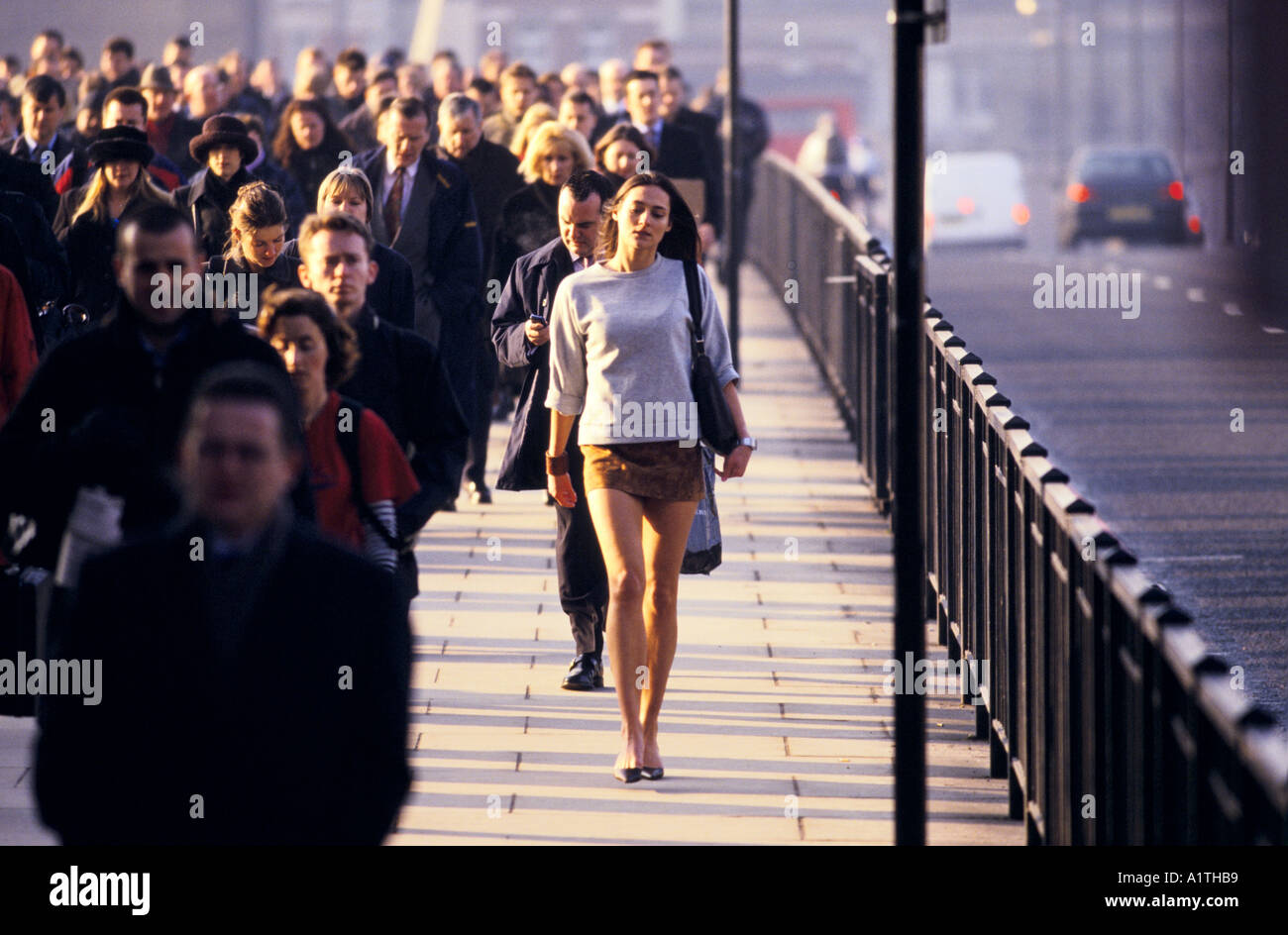 Donna che indossa mini gonna intorno a Londra Rush Hour del ponte di Londra 2001 Foto Stock