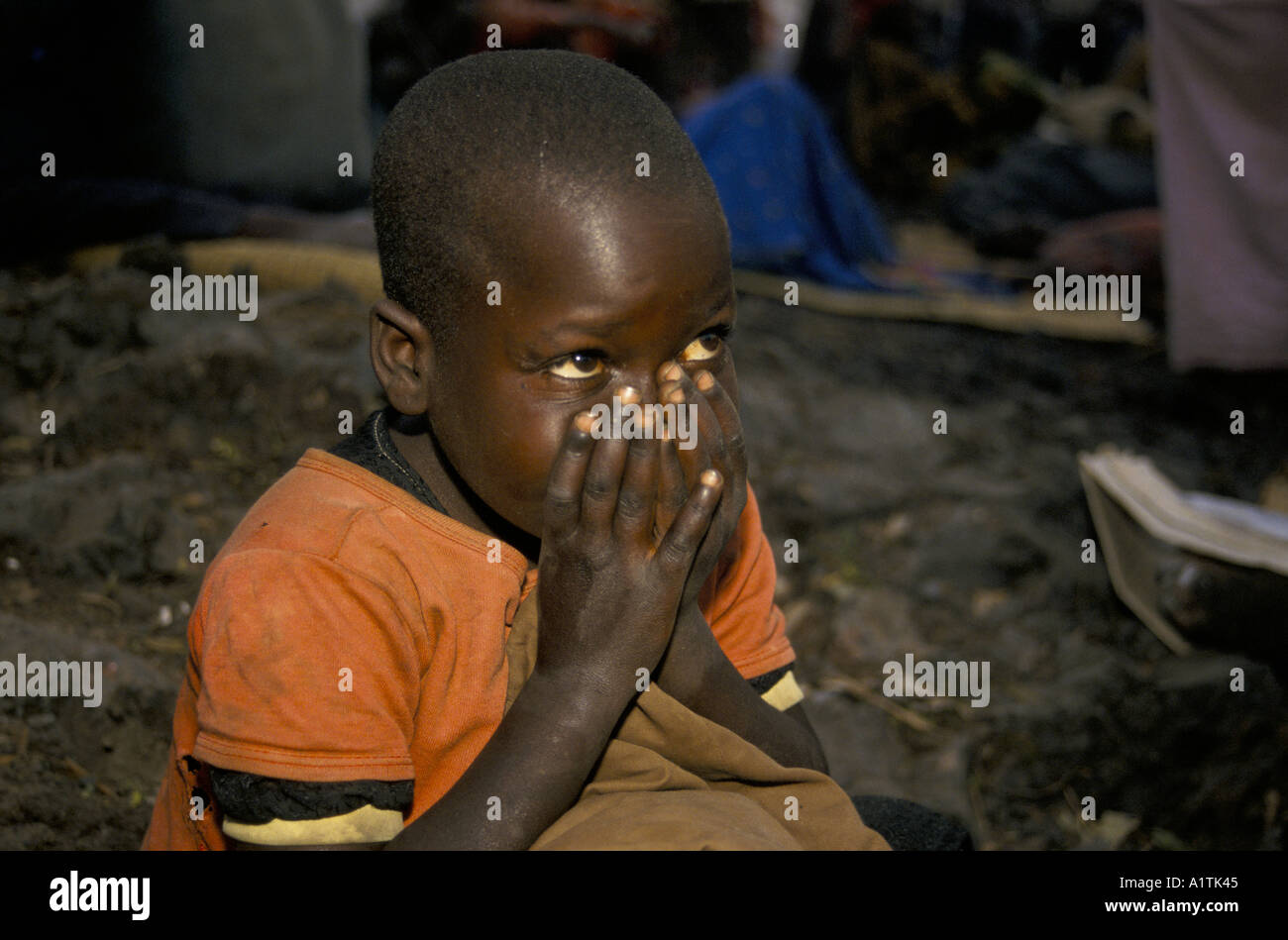 GOMA DELLO ZAIRE profughi ruandesi in KIBUMBA REFUGEE CAMP LUGLIO 1994,bambino seduto con le mani davanti al suo volto. Foto Stock