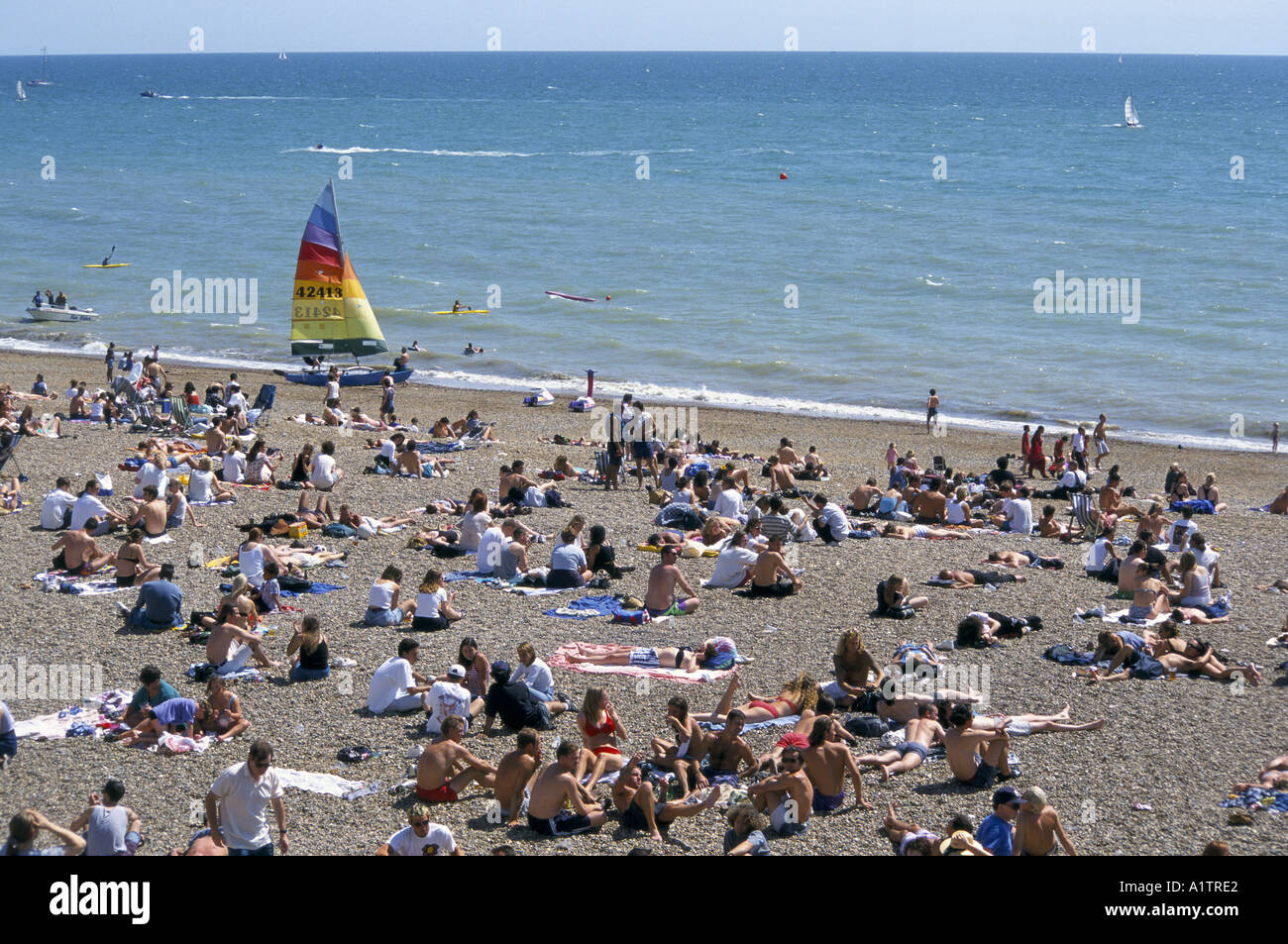 Scena sulla spiaggia di Brighton Luglio 1995 con windsurf e barca lucertole da mare Foto Stock