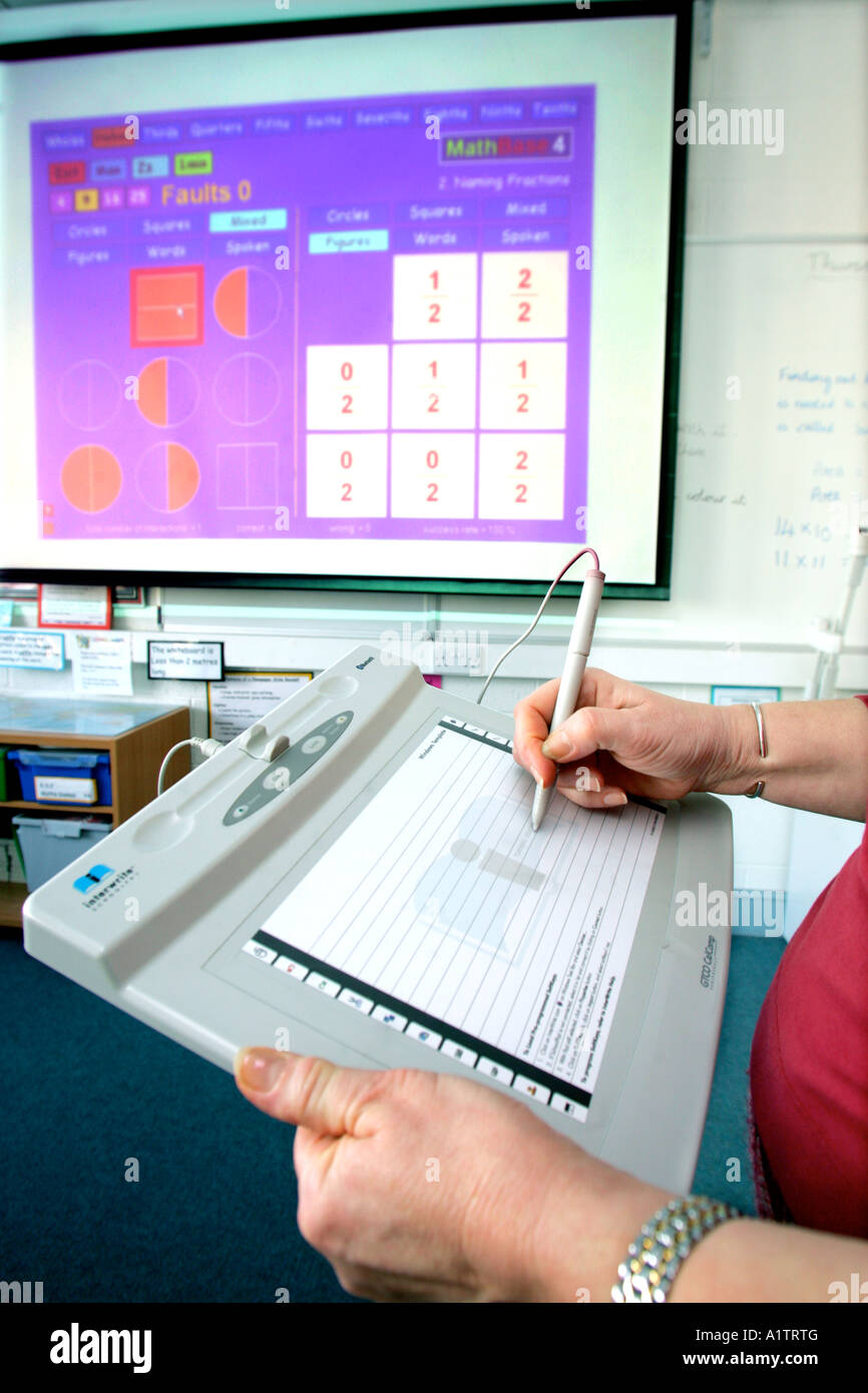 Insegnante utilizzando un wireless schoolboard teaching aiuto in un classrom legati al sistema elettronico di lavagna interattiva Foto Stock