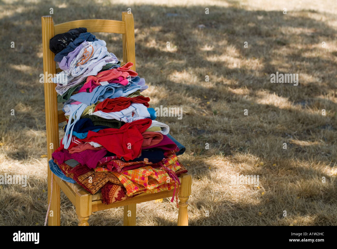 Pila di lavanderia su una sedia nel cortile. Foto Stock