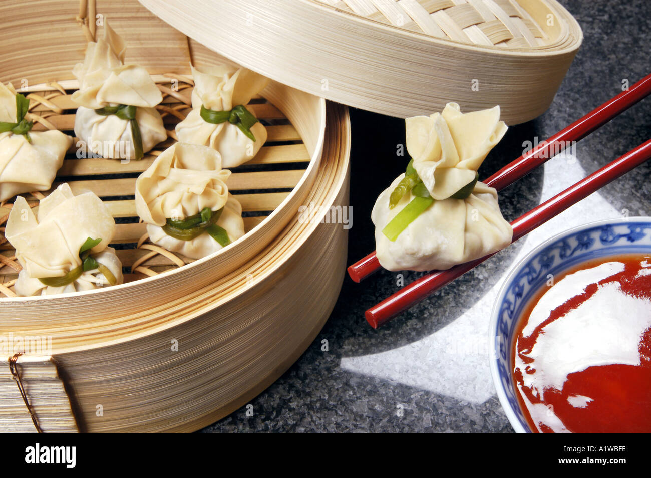 DIM SUM preparato in bambù vaporizzatore con red hot salsa vapore mangiare cibo asiatico Foto Stock