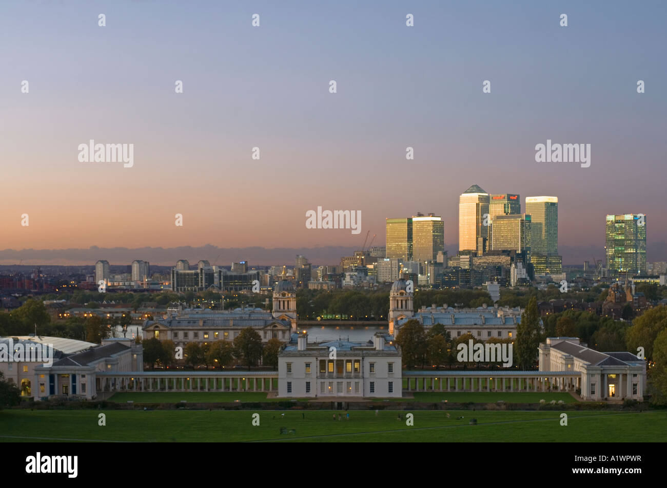 Canary Wharf da Greenwich Park con la Old Royal Naval College e Queens House in primo piano al tramonto, crepuscolo. Foto Stock