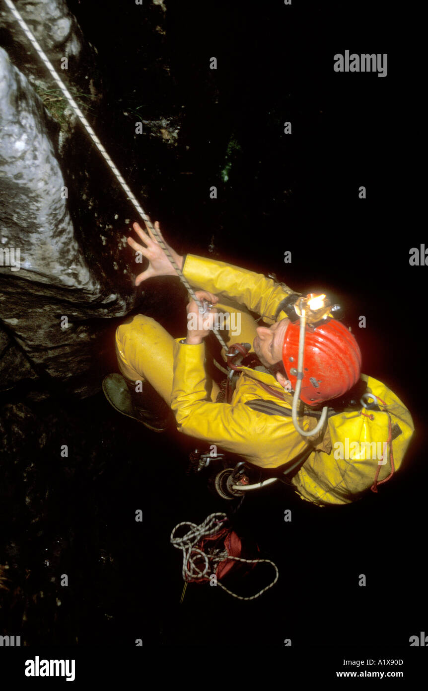 Speleologo utilizzando SRT corda singola tecnica in una grotta nel Yorkshire Dales REGNO UNITO Foto Stock