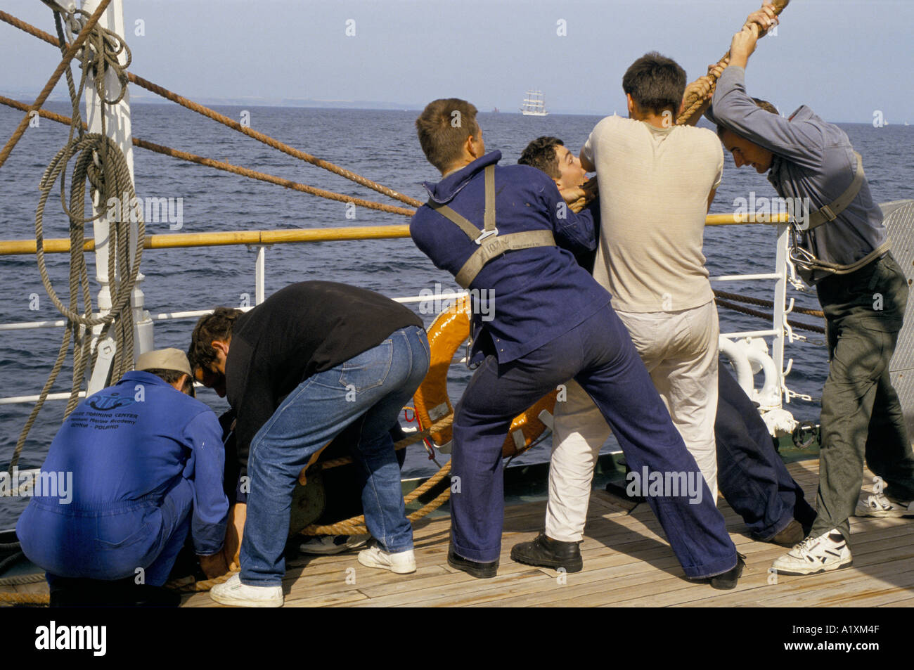 Ragazzi tirare forte sulle corde pesanti come parte della vita quotidiana sul Tall Ship Dar MLODZIEZY LO SPIRITO DELLA GIOVENTÙ Foto Stock