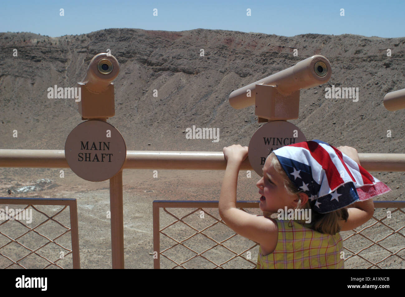 Una giovane ragazza con una bandiera americana fazzoletto attorno alla sua testa si erge su un Meteor Crater piattaforma di visualizzazione il sito di impatto di un grande meteorite è aperto come un attrazione turistica appena fuori la Interstate 40 Foto Stock